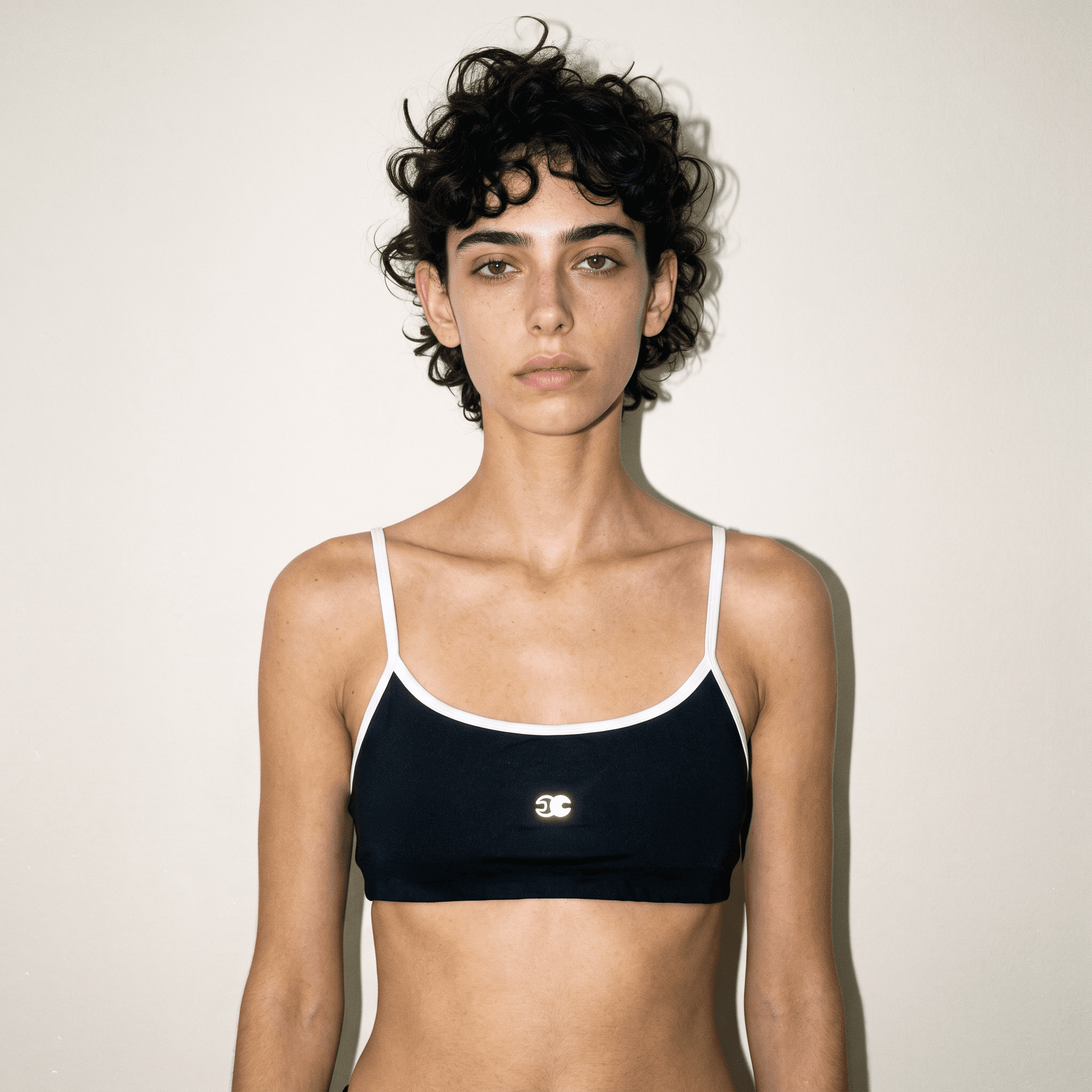 Velocity Track Bra – Black & White Front View Model wearing the black Velocity Track Bra with white contrast piping, scoop neckline, slim straps, and Conscious Choice logo.